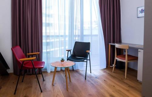 a room with chairs and a table and a desk at Hotel Belmur in Murska Sobota