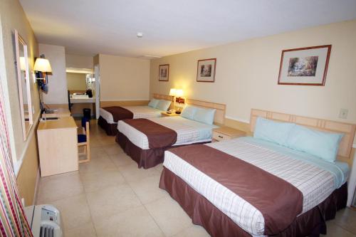 a hotel room with two beds and a bathroom at Edinburg Executive Inn in Edinburg
