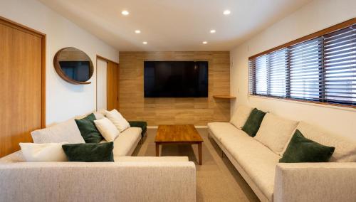 a living room with two couches and a tv at ASAE in Azagawa