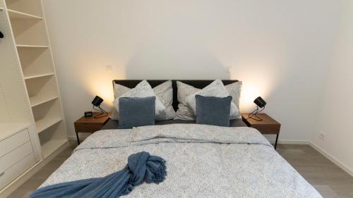 ein Schlafzimmer mit einem großen Bett mit blauer Bettwäsche und Kissen in der Unterkunft Villa al Cedro in Muralto