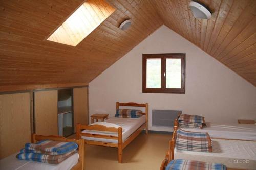 a attic room with three beds and a skylight at Gîte d'étape La Pierre in Saint-Colomban-des-Villards