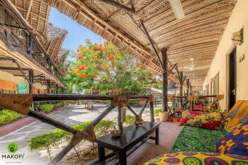 um quarto com uma mesa e uma árvore em Makofi Guest House em Nungwi