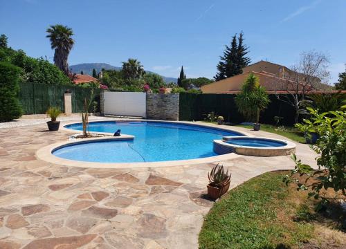 een zwembad in een tuin met een patio bij Villa au calme avec piscine privative in Bormes-les-Mimosas