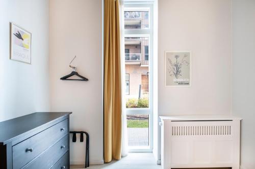 a room with a dresser and a door with a window at The Beach apartments by Daniel&Jacob's in Copenhagen