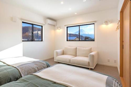 1 Schlafzimmer mit 2 Betten, einem Sofa und Fenstern in der Unterkunft ASAE in Azagawa