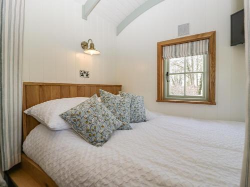 a bedroom with a bed with pillows and a window at Acorn in Weston-super-Mare