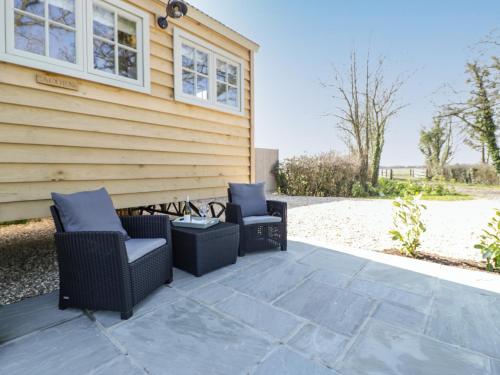 a patio with two chairs and a table at Acorn in Weston-super-Mare