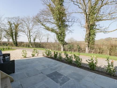 a patio with plants and trees in the background at Acorn in Weston-super-Mare