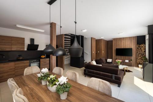a kitchen and living room with a table and a couch at Zerm Holiday House with pool, jacuzzi & sauna - Gorski kotar in Mrkopalj
