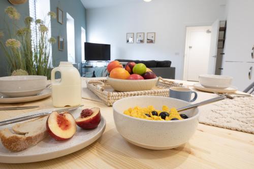 una mesa con un tazón de cereales y un tazón de fruta en Courtyard Retreat, en Southampton