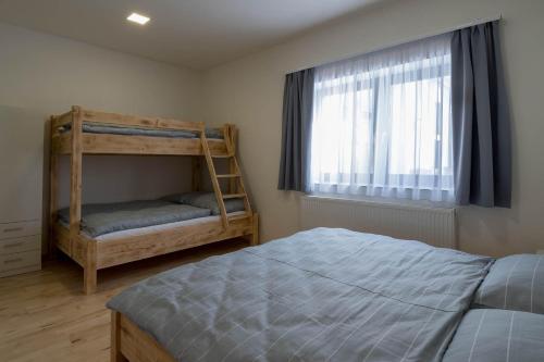 a bedroom with a bunk bed and a window at Apartmány Family aréna in Benecko