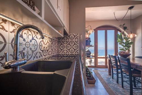 a kitchen with a sink and a view of the ocean at Helios Selene in Vívlos