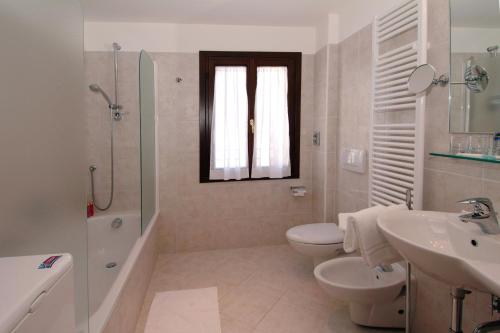 y baño con lavabo, aseo y ducha. en Residence Corte Grimani, en Venecia
