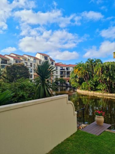 a view of a apartment complex from the water at Island Club by Smart City Stays in Cape Town