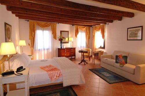 ein Schlafzimmer mit einem großen Bett und ein Wohnzimmer in der Unterkunft Residence Corte Grimani in Venedig