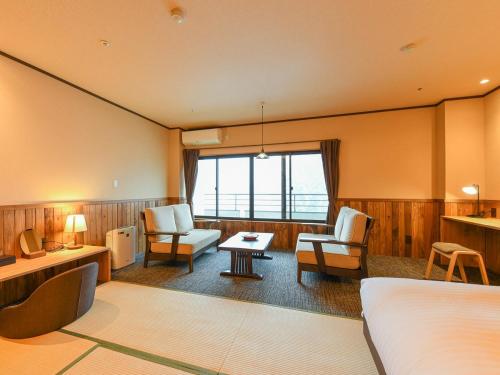 a hotel room with a bed and a living room at Kutsurogijuku Chiyotaki in Aizuwakamatsu