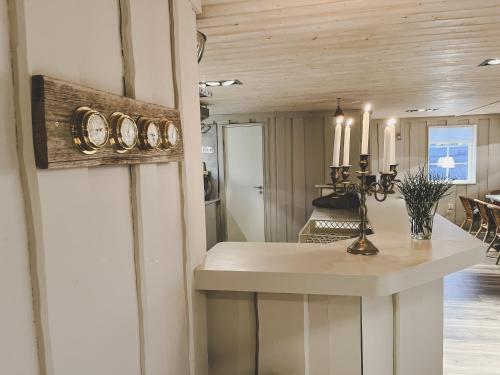 Väjern的住宿－Havets Magasin，厨房配有一张桌子,墙上挂着一个时钟