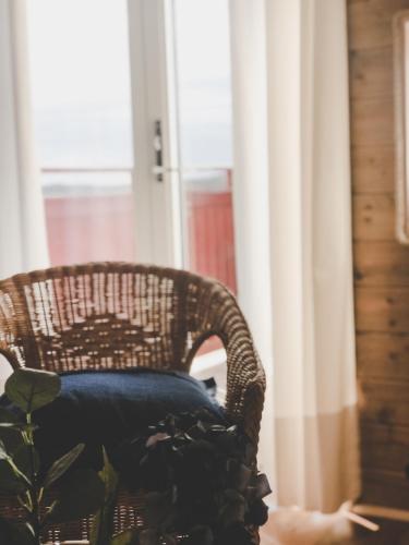 a wicker chair sitting in front of a window at Havets Magasin in Väjern