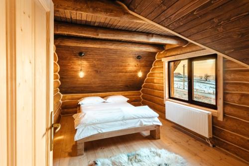 a room with two beds in a log cabin at Poeme Chalet in Râșca