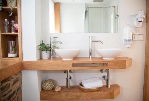 a bathroom with two sinks and a mirror at Pensión Praza das Coles in Melide