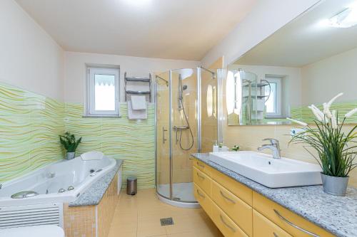 ein Bad mit einer Badewanne, einem Waschbecken und einer Dusche in der Unterkunft Pool Villa Ana Residence in Gradac