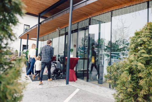 a family walking outside of a glass building at Hotel Bon Alpina in Innsbruck