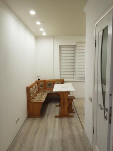 リウネにあるКвартира в стилі хай текの木製のベンチとテーブルが備わる客室です。