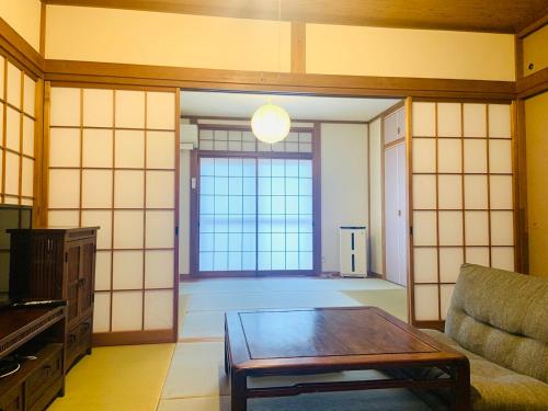 a living room with a table and a large window at Yokohama HY House in Yokohama