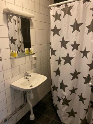 a bathroom with a sink and a shower curtain with stars at Bruksmässen Hotell in Degerfors