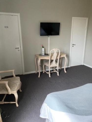 sypialnia ze stołem, krzesłem i telewizorem w obiekcie Bruksmässen Hotell w mieście Degerfors