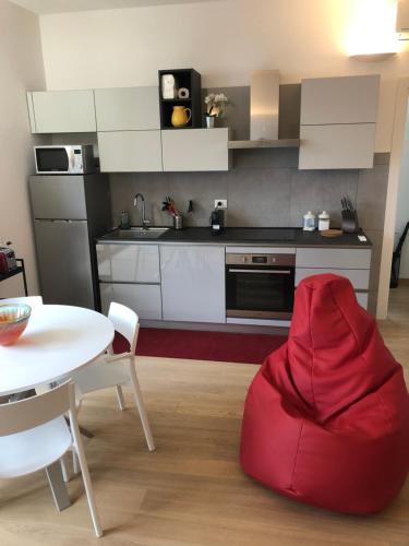 uma cozinha com um pufe de feijão vermelho e uma mesa em Music House - Carozzi Apartments em Milão