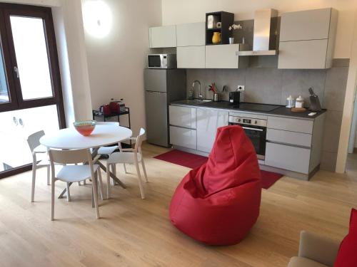 cocina con mesa y silla roja en Music House - Carozzi Apartments, en Milán