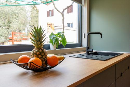 a bowl of fruit on a kitchen counter next to a sink at House 1119 in Muntić