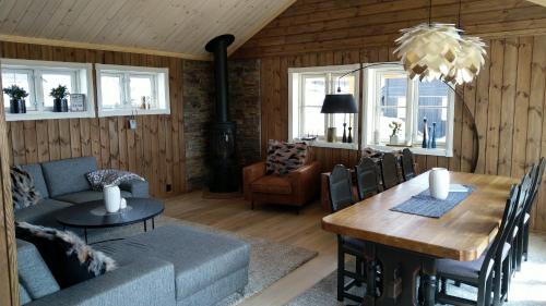 a living room with a couch and a dining room table at Wonderful cabin with amazing mountain - view in Lifjell