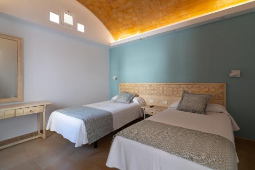 two beds in a room with blue walls at Bungalows Cordial Biarritz in Playa del Ingles