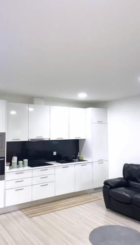 ein Wohnzimmer mit weißen Schränken und einer schwarzen Couch in der Unterkunft Lisboa New in Bobadela