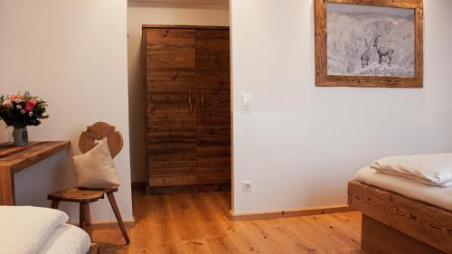 a bedroom with a bed and a wooden door at Hotel Almwirt in Haar