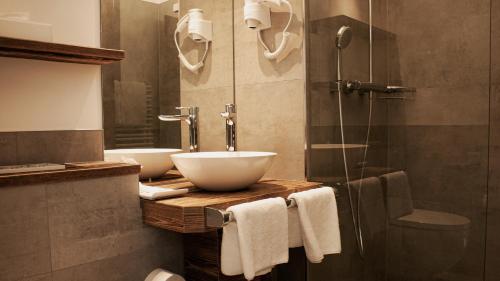 a bathroom with two sinks and a shower at Hotel Almwirt in Haar