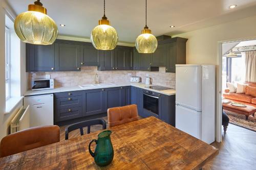 cocina con armarios azules y mesa de madera en Host & Stay - Fox Cottage, en Bellingham