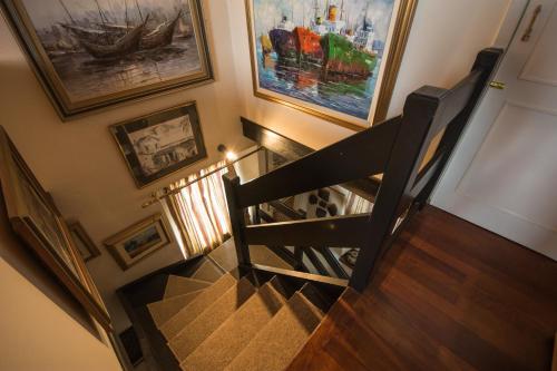 a hallway with a staircase with paintings on the wall at Iokasti House Ipsos Corfu in Ágios Márkos