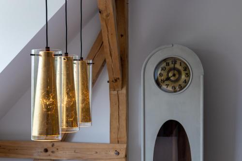 four lights hanging from a wall next to a clock at ALTE SCHULE WITTENBERG, 3 Ferienwohnungen für bis zu 12 Personen, an der Elbe, mit Garten in Lutherstadt Wittenberg