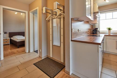 een keuken met een aanrecht en een hal met een slaapkamer bij Strandmuschel in Zingst