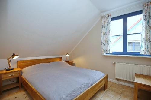 um quarto com uma cama e uma janela em Feriendorf Papillon Wohnung 05-5 em Boltenhagen