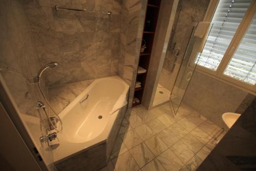 La salle de bains est pourvue d'une douche, d'une baignoire et d'un lavabo. dans l'établissement Hotel MARIOTTO am Burghof, à Lörrach