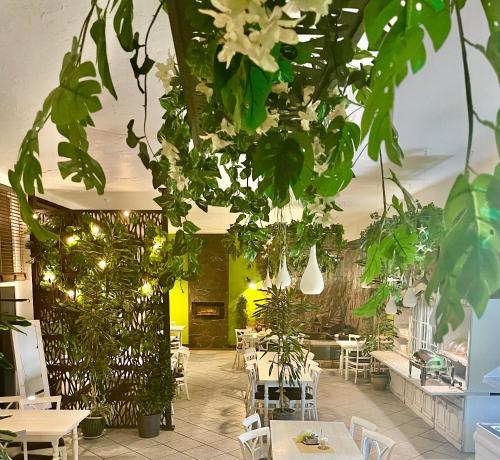 a restaurant with white tables and green plants at Polonez w Rymaniu in Rymań