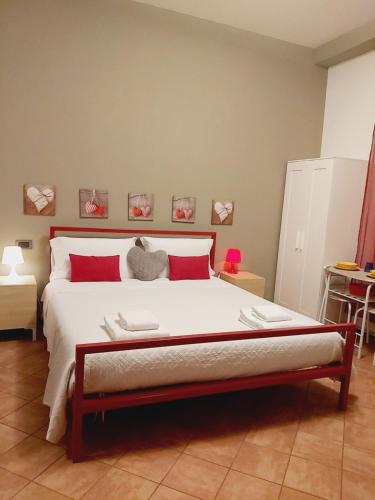 a bedroom with a large bed with red pillows at LODGING 5 TERRE & PORTO LA SPEZIA in La Spezia