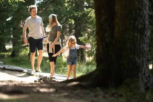 a family walking on a path in the woods at Hotel Planja in Zreče