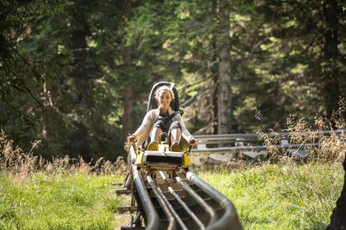 a little girl riding on a toy train at Hotel Planja in Zreče