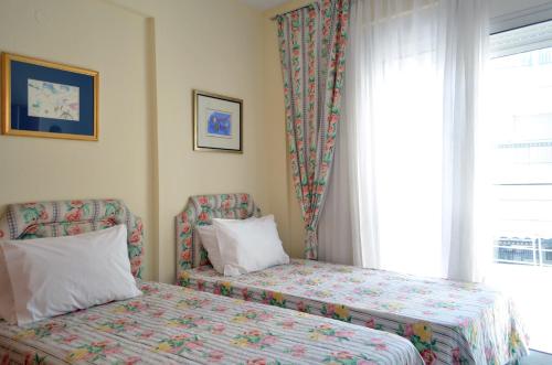a bedroom with two beds and a window at Delmare Dion apartment in Thessaloniki