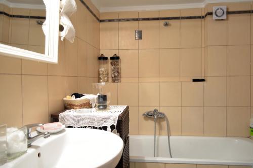a bathroom with a sink and a bath tub at Delmare Dion apartment in Thessaloniki